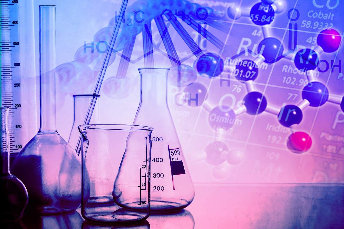 Artistic photo of lab glassware and a section of the periodic table of th elements.